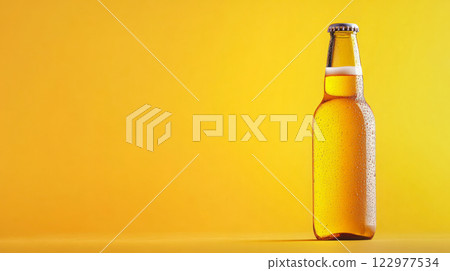 Cold beer bottle with condensation droplets on a bright yellow background, perfect for beverage advertising or summer promotions. 122977534