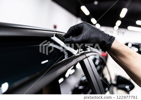 Car wash or detailing studio employee applies ceramic or graphene coating Car wash or detailing studio employee applies ceramic or graphene coating 122977781