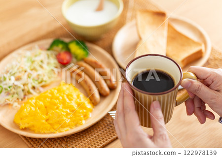 Middle-aged woman eating a Western-style breakfast Middle-aged woman eating a Western-style breakfast 122978139