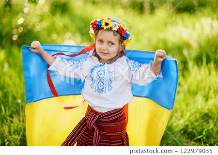 Ukraines Independence Flag Day. Constitution day. Ukrainian child girl in embroidered shirt vyshyvanka with yellow and blue flag of Ukraine in field. flag symbols of Ukraine. Kyiv, Kiev day Ukraines Independence Flag Day. Constitution day. Ukrainian child girl in embroidered shirt vyshyvanka with yellow and blue flag of Ukraine in field. flag symbols of Ukraine. Kyiv, Kiev day 122979035