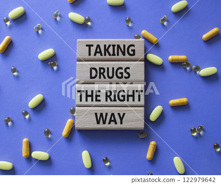 Medicine symbol. Concept word Taking drugs the right way on wooden blocks. Beautiful purple background with pills. Medicine concept. Copy space 122979642