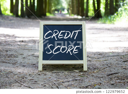 Credit Score symbol. Blackboard with words Credit Score. Beautiful forest background. Business and Credit Score concept. Copy space. 122979652