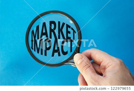 Market impact symbol. Concept word Market impact on magnifying glass. Beautiful blue background. Businessman hand. Business and Market impact concept. Copy space. Market impact symbol. Concept word Market impact on magnifying glass. Beautiful blue background. Businessman hand. Business and Market impact concept. Copy space. 122979655