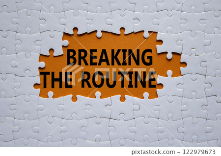 Breaking the Routine symbol. White puzzle with words Breaking the Routine. Beautiful orange background. Business and Breaking the Routine concept. Copy space. 122979673