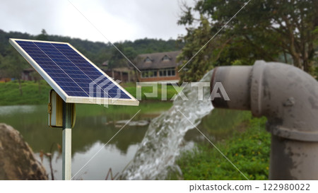 A solar panel installed to power a water pump, for residential area. Promoting sustainable living and renewable energy use. 122980022