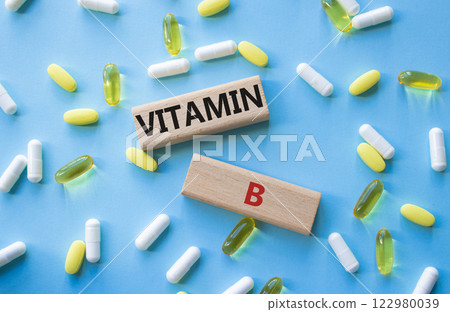 Vitamin B symbol. Concept word Vitamin B on wooden blocks. Beautiful blue background with pills. Medicine and Vitamin B concept. Copy space Vitamin B symbol. Concept word Vitamin B on wooden blocks. Beautiful blue background with pills. Medicine and Vitamin B concept. Copy space 122980039