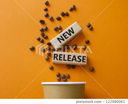 New Release symbol. Concept word New Release on wooden blocks. Beautiful orange background with coffee cup. Business and New Release concept. Copy space 122980061