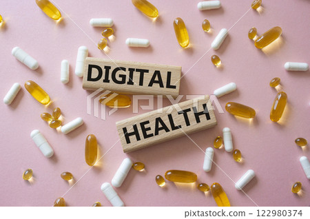 Digital Health symbol. Concept word Digital Health on wooden blocks. Beautiful pink background with pills. Medicine and Digital Health concept. Copy space 122980374
