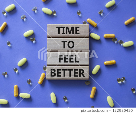 Time to feel better symbol. Concept word Time to feel better on wooden blocks. Beautiful purple background with pills. Health concept. Copy space Time to feel better symbol. Concept word Time to feel better on wooden blocks. Beautiful purple background with pills. Health concept. Copy space 122980430
