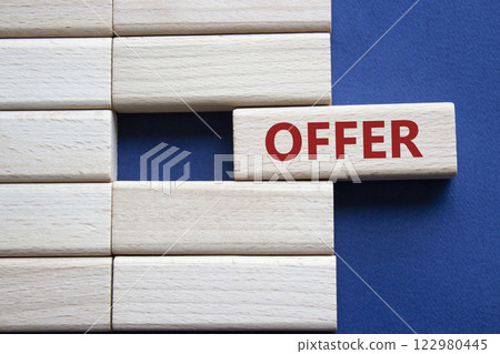 Offer symbol. Concept word offer on wooden blocks. Beautiful deep blue background. Business and offer concept. Copy space. 122980445