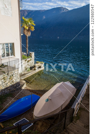 Boats pn shore in waiting of spring on Lugano lake Boats pn shore in waiting of spring on Lugano lake 122980547