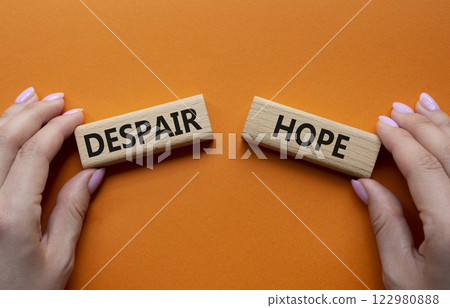Despair or Hope symbol. Concept word Despair or Hope on wooden blocks. Businessman hand. Beautiful orange background. Business and Despair or Hope concept. Copy space 122980888