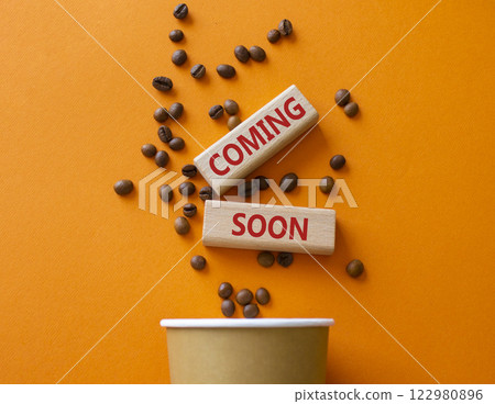Coming Soon symbol. Concept word Coming Soon on wooden blocks. Beautiful orange background with coffee cup. Business and Coming Soon concept. Copy space Coming Soon symbol. Concept word Coming Soon on wooden blocks. Beautiful orange background with coffee cup. Business and Coming Soon concept. Copy space 122980896