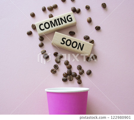 Coming Soon symbol. Concept word Coming Soon on wooden blocks. Beautiful pink background with coffee cup. Business and Coming Soon concept. Copy space 122980901