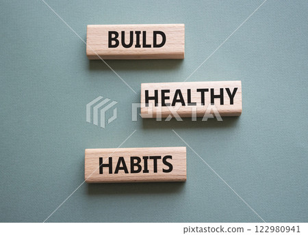 Healthy habits symbol. Concept word Build Healthy habits on wooden blocks. Beautiful grey green background. Healthy lifestyle and Healthy habits concept. Copy space 122980941