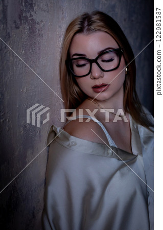 An Elegant and Artistic Portrait Depicting a Woman with Glasses Surrounded by Soft Lighting 122981587