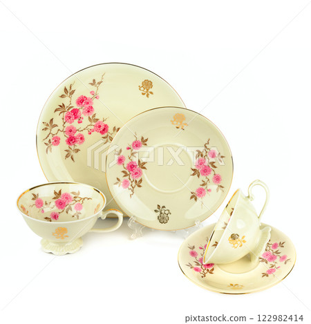 Vintage porcelain cups and saucers isolated on white background. Free space for text. Vintage porcelain cups and saucers isolated on white background. Free space for text. 122982414