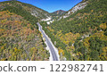 Asphalt road between the mountains and green, yellow trees. Nature landscape in the autumn 122982741