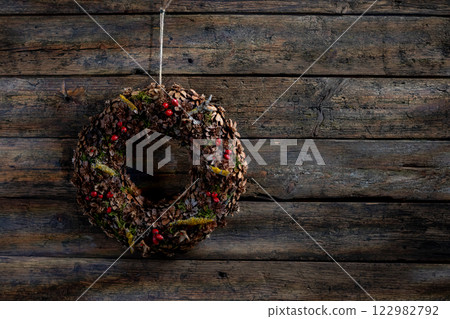 A Beautiful Rustic Winter Wreath Displayed on a Weathered Wood Background for a Cozy Look 122982792