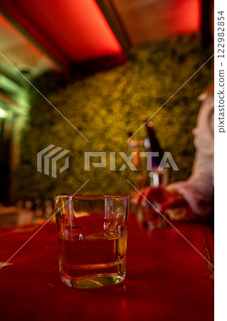 A trendy bar with elegant glassware and ambient lighting for a perfect atmosphere A trendy bar with elegant glassware and ambient lighting for a perfect atmosphere 122982854