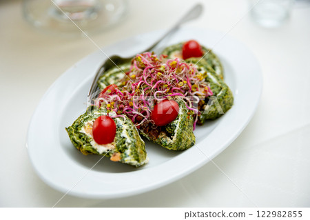 Enjoy a Delicious Spinach Roll filled with Fresh Cherry Tomatoes and Healthy Sprouts 122982855