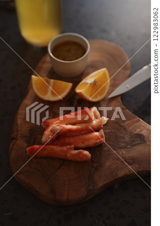 Crab legs with lemon and dressing on olive woob board 122983062