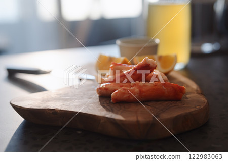 Crab legs with lemon and dressing on olive woob board 122983063