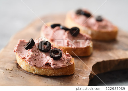 Ciabatta with meat paste on olive wowod board 122983089