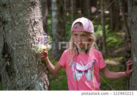 Little blonde with spring wildflowers 122983221