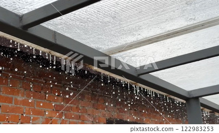 Heavy rain drumming on the transparent plexiglass roof. Beautiful rainy scene on summer day. Concept of tranquility nature scene. Close up Slow motion Heavy rain drumming on the transparent plexiglass roof. Beautiful rainy scene on summer day. Concept of tranquility nature scene. Close up Slow motion 122983253