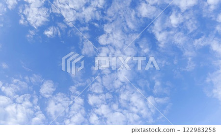 Camera move behind white fluffy clouds on blue sky at summer sunny day. Beautiful nature background. Close up Slow motion 122983258