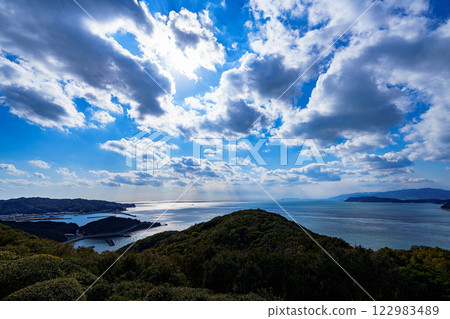 Wakayama Kitan Strait enveloped in the soft winter sunlight. The sun shining through the clouds and the sparkling sea. 122983489