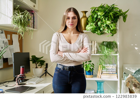Portrait of young confident smiling woman in home interior 122983839
