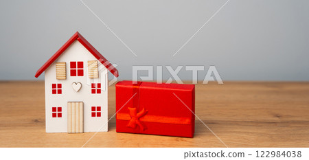 Miniature house and gift box. Housing as a gift. Win an apartment in the lottery. To inherit property. Holiday discounts. Buying an apartment at a low price. Sale of real estate. Present Miniature house and gift box. Housing as a gift. Win an apartment in the lottery. To inherit property. Holiday discounts. Buying an apartment at a low price. Sale of real estate. Present 122984038