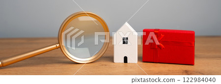 Miniature house and gift box. Housing as a gift. Win an apartment in the lottery. To inherit property. Holiday discounts. Buying an apartment at a low price. Sale of real estate. Present Miniature house and gift box. Housing as a gift. Win an apartment in the lottery. To inherit property. Holiday discounts. Buying an apartment at a low price. Sale of real estate. Present 122984040