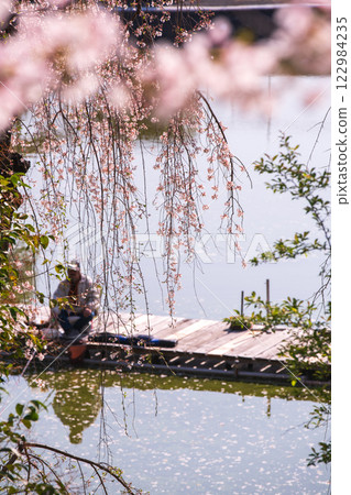 Photographing cherry blossoms at a fishing pond in Yawata, Kyoto Prefecture, where people can enjoy fishing in a tranquil setting Photographing cherry blossoms at a fishing pond in Yawata, Kyoto Prefecture, where people can enjoy fishing in a tranquil setting 122984235