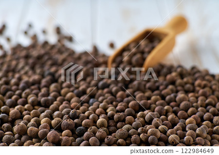 allspice or Jamaican pepper on a white wooden table, selective focus. 122984649