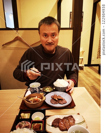 一名男子津津有味地吃著牛舌套餐 一名男子津津有味地吃著牛舌套餐 122984938