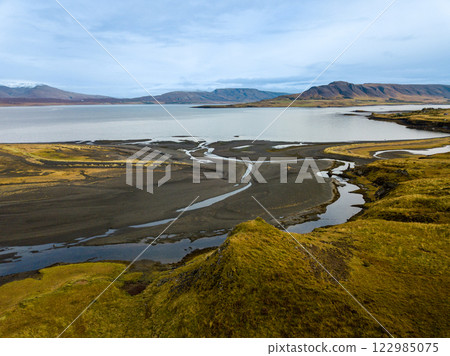 Aerial perspective of a braided river delta meeting hvalfjörður fjord in iceland, forming a picturesque scenery 122985075