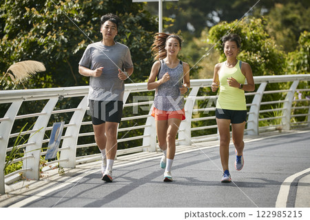 young asian adults running jogging outdoors 122985215