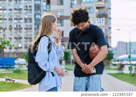 Young teenage guy and girl talking, walking together, urban background Young teenage guy and girl talking, walking together, urban background 122985587