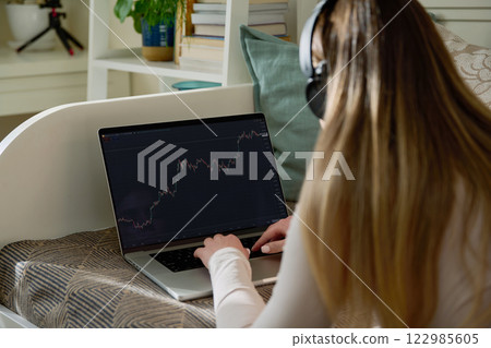 Laptop screen with market analysis charts, woman working on computer, rear view Laptop screen with market analysis charts, woman working on computer, rear view 122985605