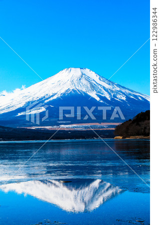 A clear winter sky and a snow-covered inverted Mt. Fuji in the harsh winter as seen from Lake Yamanaka 122986344