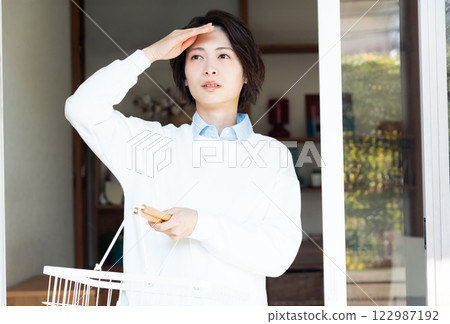 Woman looking outside from the living room Woman looking outside from the living room 122987192