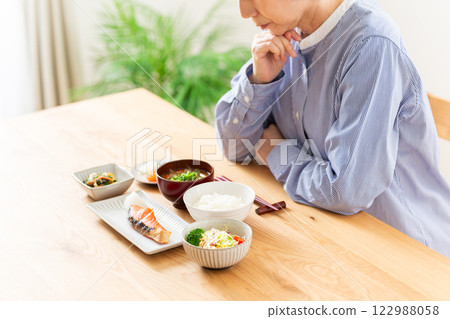 A middle-aged woman worried about her Japanese breakfast A middle-aged woman worried about her Japanese breakfast 122988058