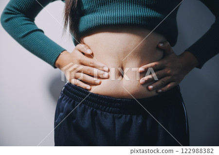 Asian Woman Pinching Her Belly Fat With Left Hand 122988382