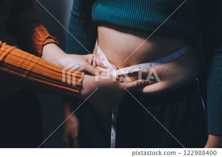 Asian Woman Pinching Her Belly Fat With Left Hand Asian Woman Pinching Her Belly Fat With Left Hand 122988400