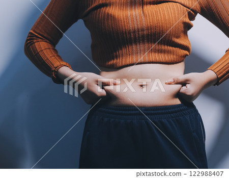 Asian Woman Pinching Her Belly Fat With Left Hand Asian Woman Pinching Her Belly Fat With Left Hand 122988407
