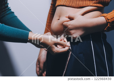 Asian Woman Pinching Her Belly Fat With Left Hand 122988430