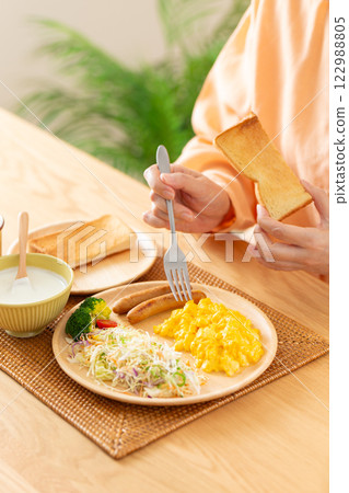 Middle-aged woman eating a Western-style breakfast 122988805